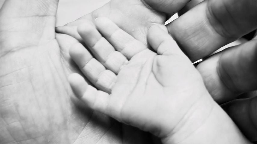 Patrick J. Adams mit der Hand seines dritten Babys