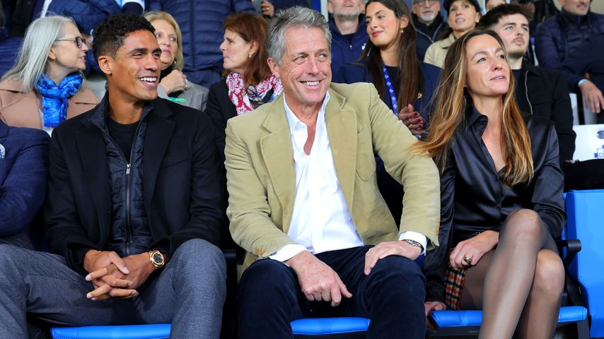 Raphaël Varane, Hugh Grant und Anna Eberstein bei einem Fußballspiel, 2024