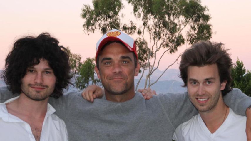 Robbie Williams (M.) mit seinen Songwritern Flynn Francis (l.) und Tim Metcalfe (r.)
