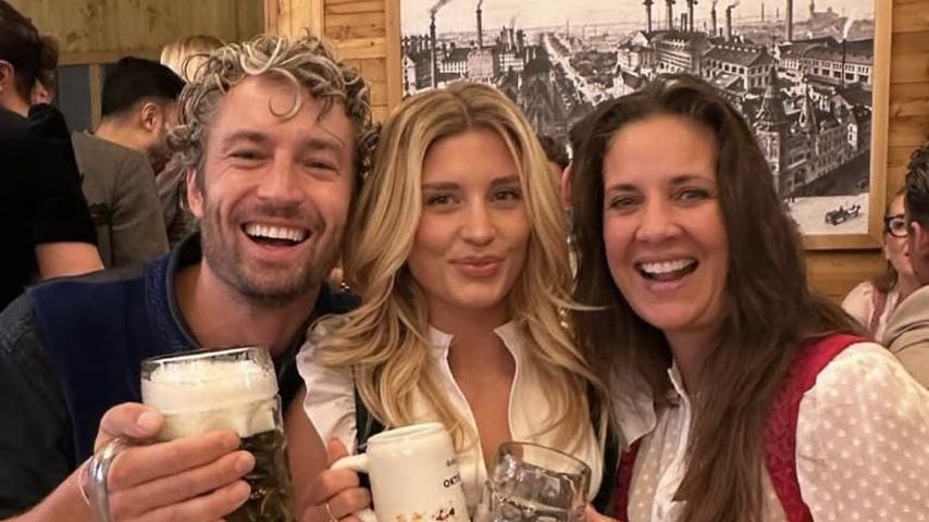 Simon Lohmeyer, Luna Schweiger und Dana Schweiger mit Bierkrügen auf dem Oktoberfest.