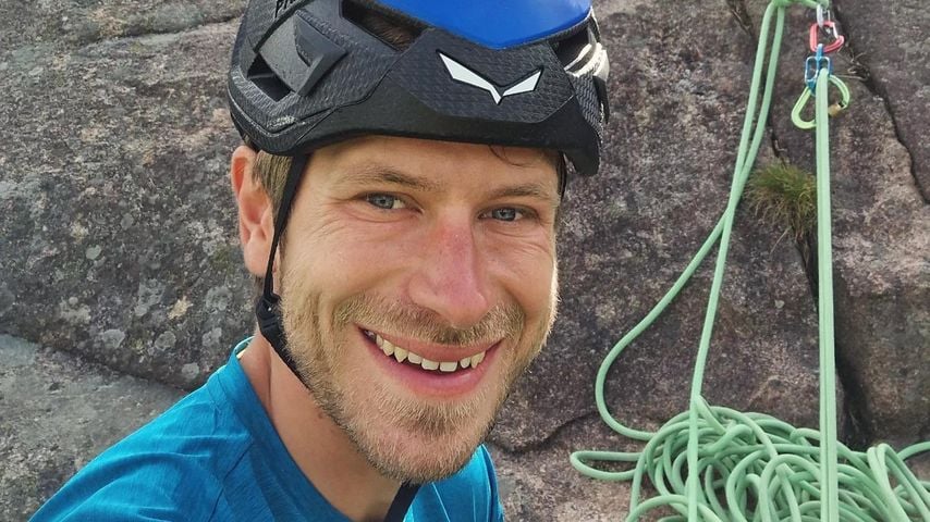 Simon Messner macht ein Selfie von sich beim Klettern, Juli 2024.