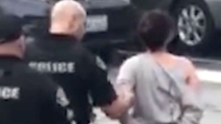 Vanessa Cloke wird von einem Polizisten abgeführt