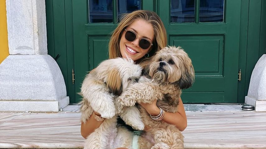 Victoria Swarovski kuschelt mit zwei Hunden.