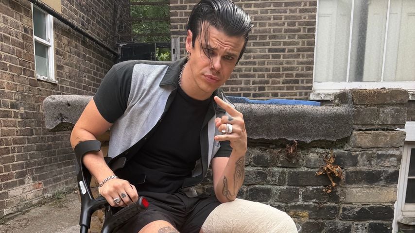 Yungblud posiert mit bandagiertem Bein und Krücken nach einem Motorradunfall, 2026.